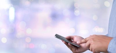 a close up of a person holding a cell phone.