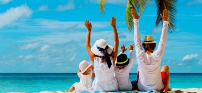 a group of people sitting on top of a sandy beach.